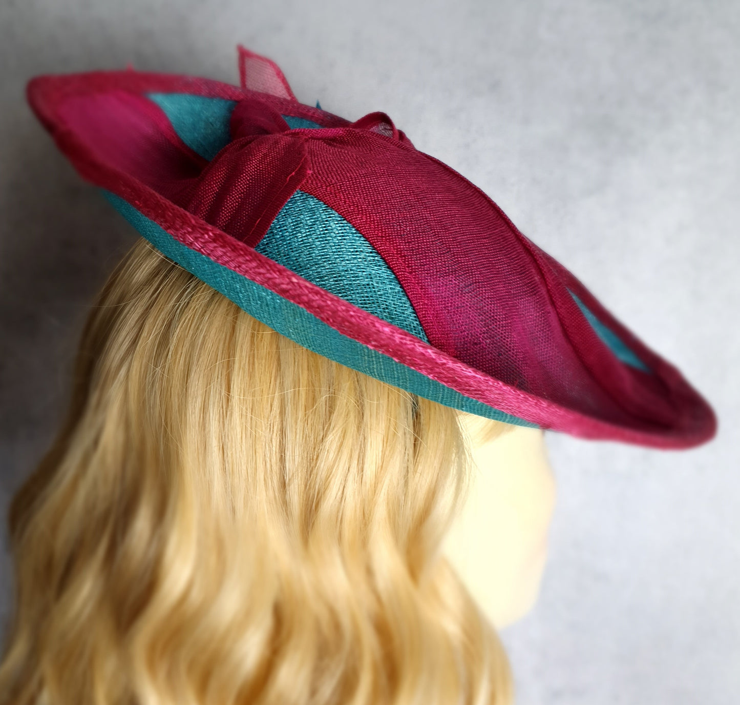 Elegant fascinator hat for women in fuchsia and blue. Handmade from sinamay with abaca silk, for weddings or formal events.