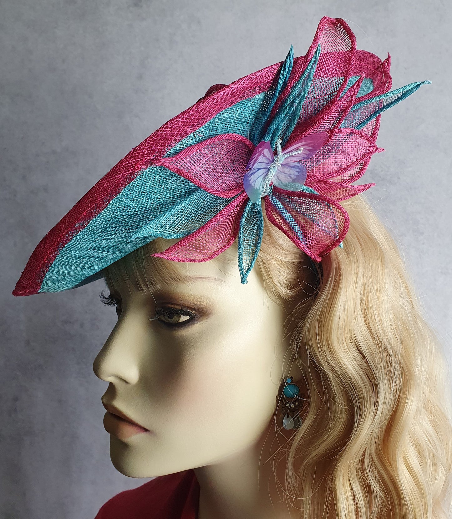 Elegante fascinator hoed voor dames in fuchsia en blauw. Handgemaakt van sinamay met abaca zijde, voor bruiloften of formele evenementen.