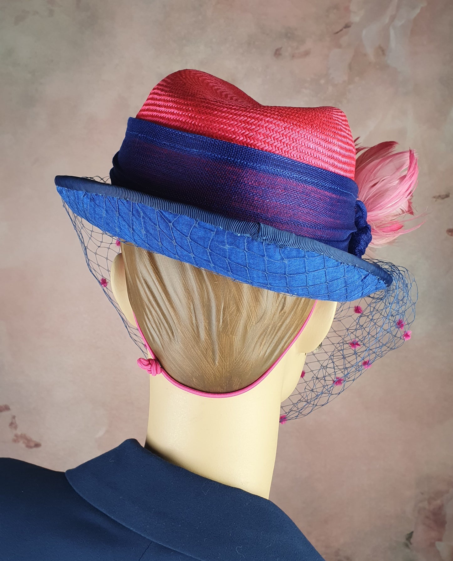 Parasisal ladies hat in the colors fuchsia and blue. Handmade with abacá silk, veil and swan feathers, elegant fascinator hat women