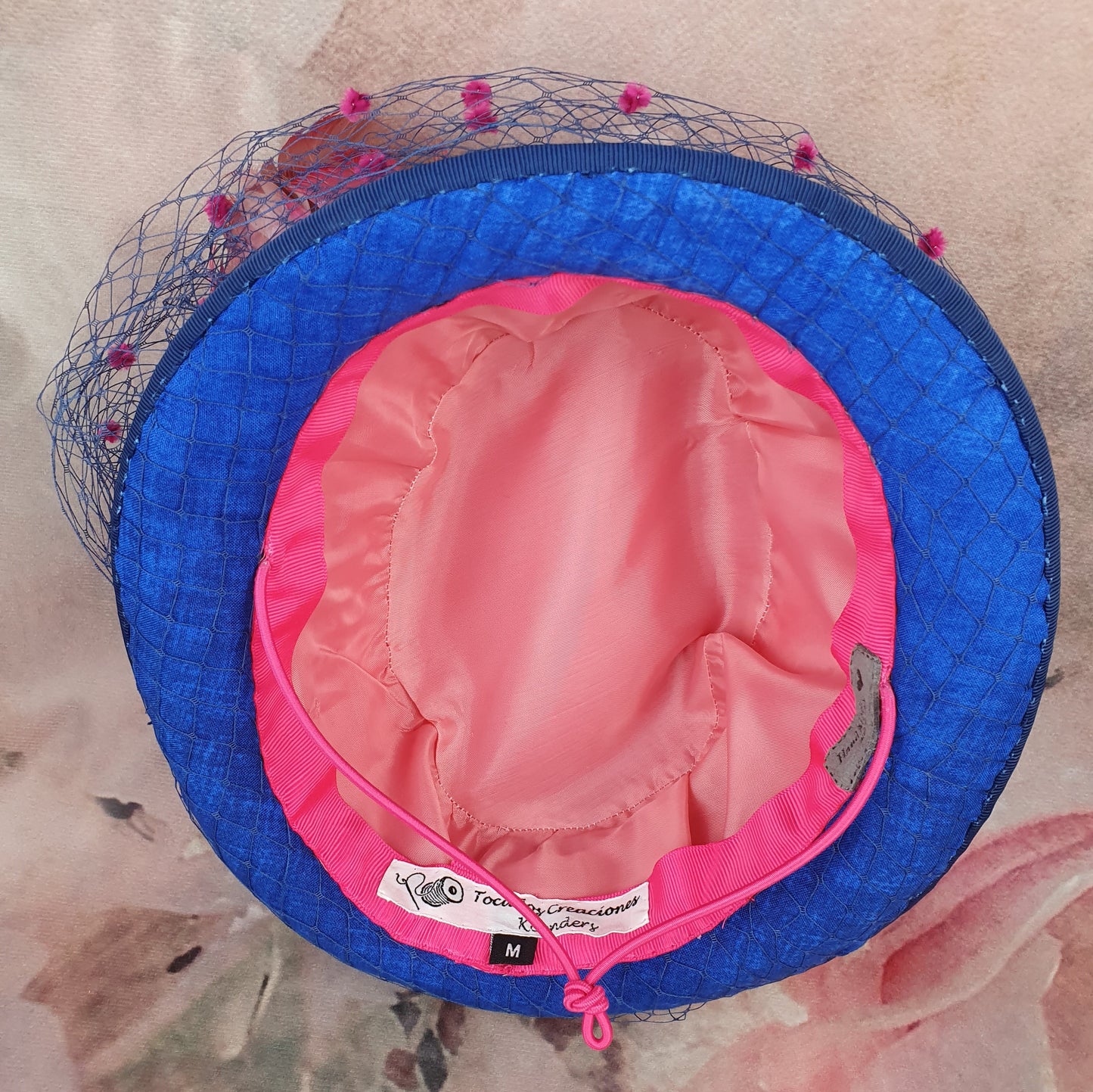 Parasisal ladies hat in the colors fuchsia and blue. Handmade with abacá silk, veil and swan feathers, elegant fascinator hat women