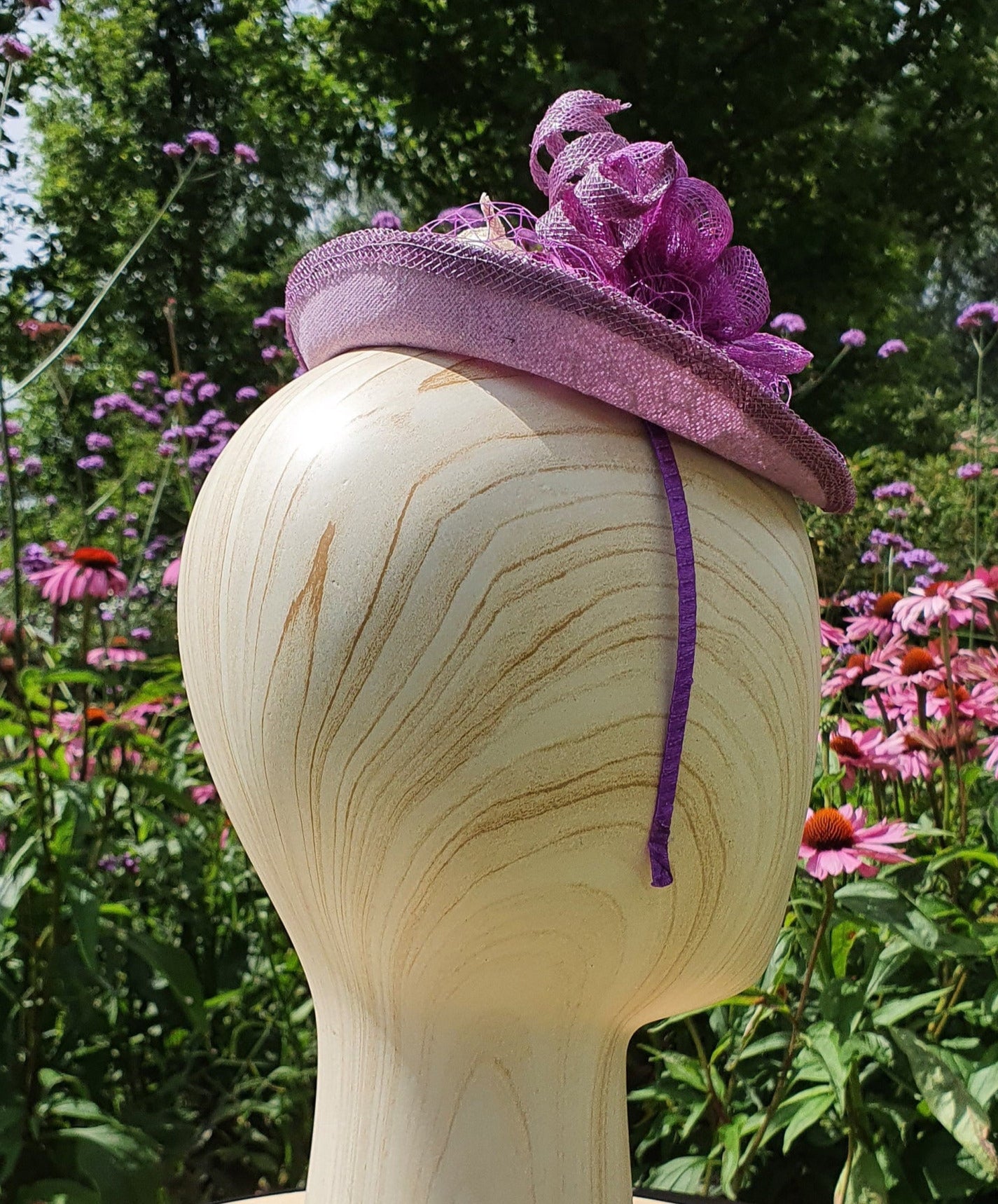 Handmade purple oval fascinator from Sinamay with pink and purple feathers and bows