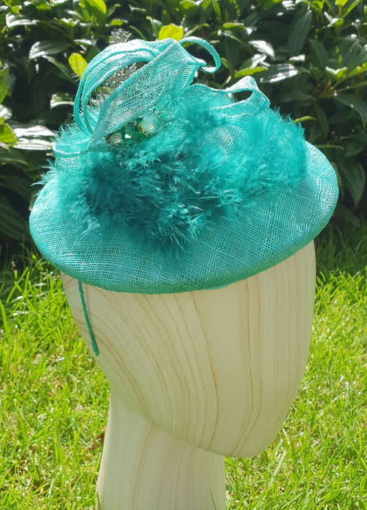 Handmade round mint green fascinator millinery from Sinamay with green feathers