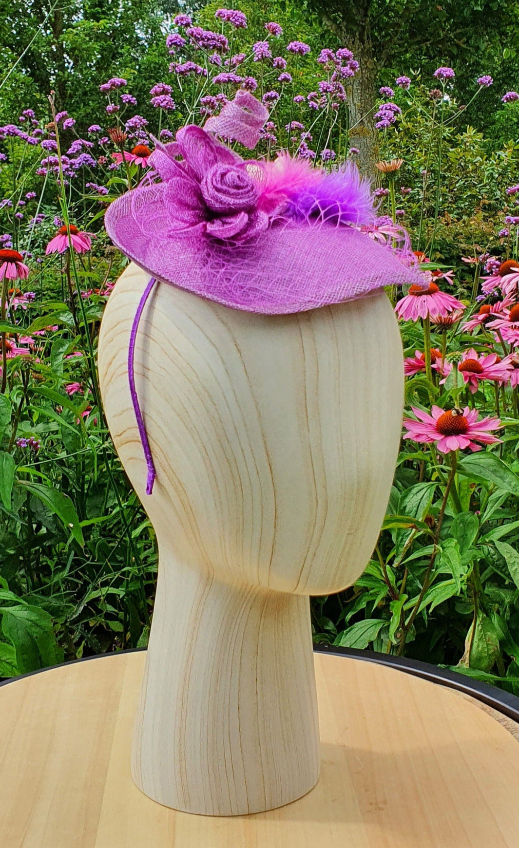 Handmade purple oval fascinator from Sinamay with pink and purple feathers and bows