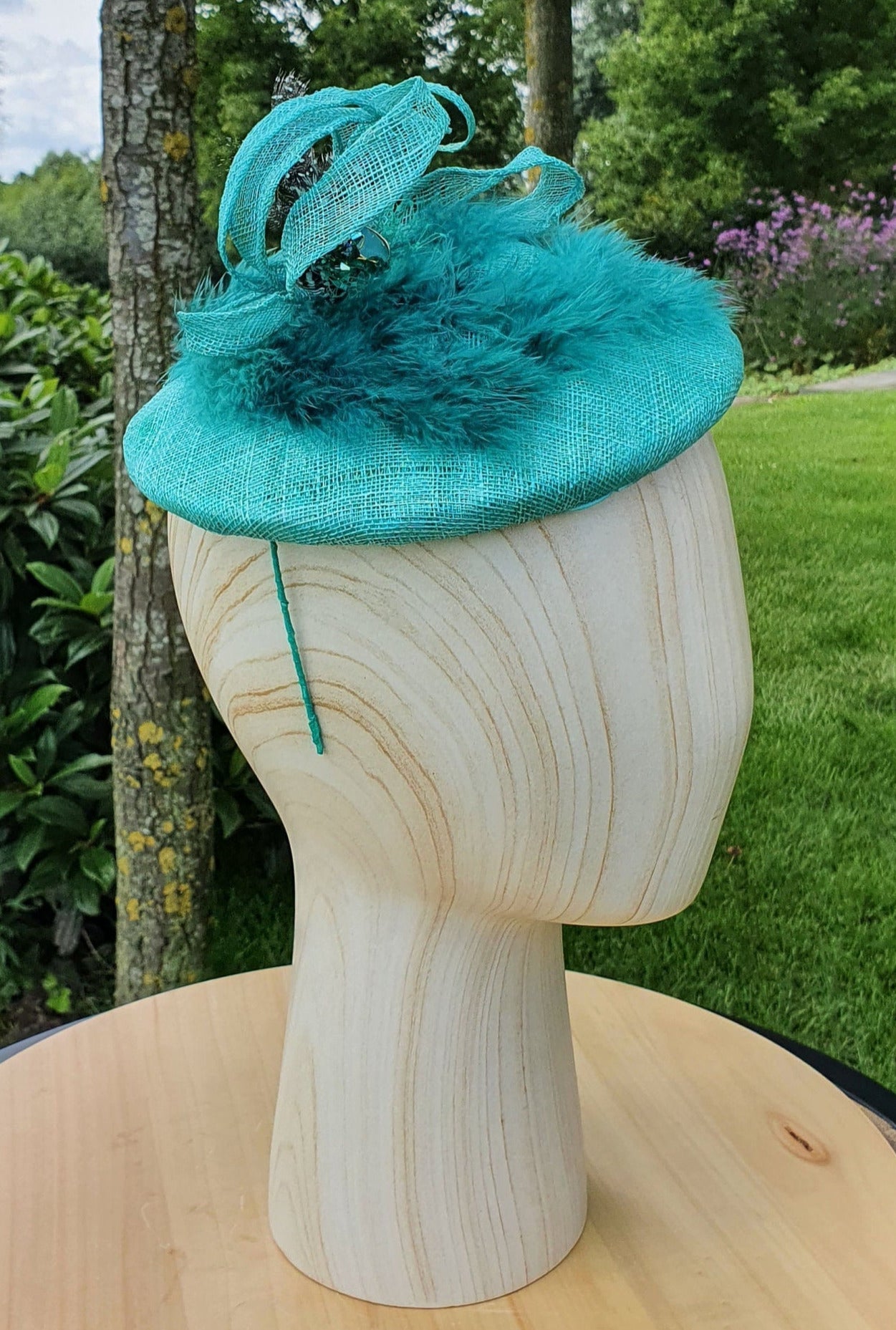 Handmade round mint green fascinator millinery from Sinamay with green feathers